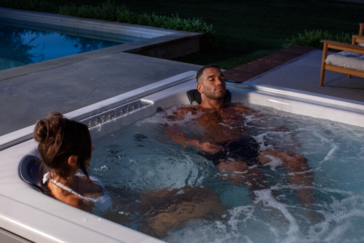 couple enjoying a hydromassage in their hot tub