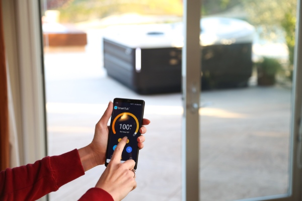 woman setting hot tub temperature using the SmartTub app