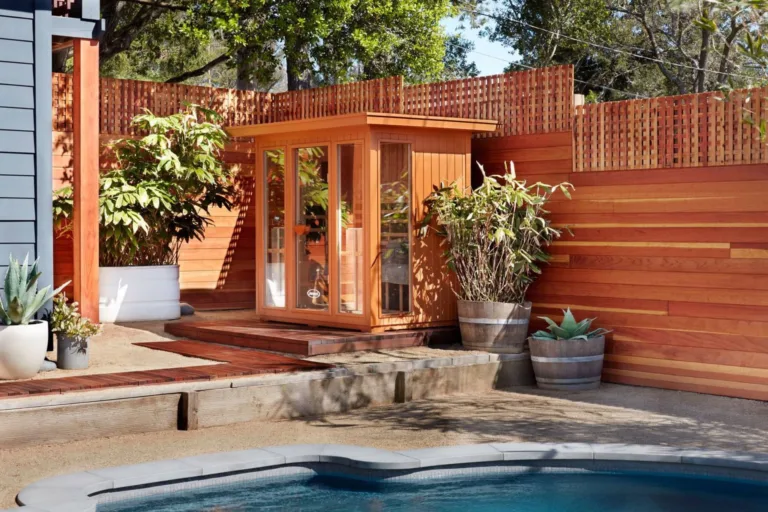 A Clearlight infrared sauna installed in the backyard with a pool