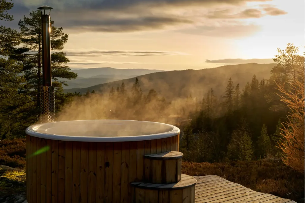 a steaming hot tub overlooking forested mountains